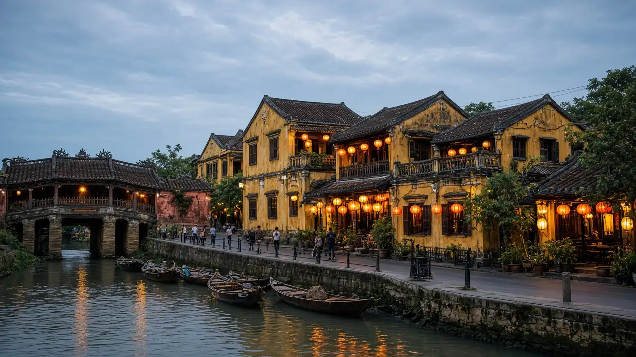 KI-Illustration: Gelbe historische Kaufmannshäuser am Fluss von Hoi An und leuchtende Seidenlaternen zur blauen Stunde, dicht bebautes städtisches Flussufer
